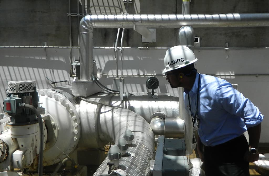 Engineer inspecting industrial plant pipework and valves